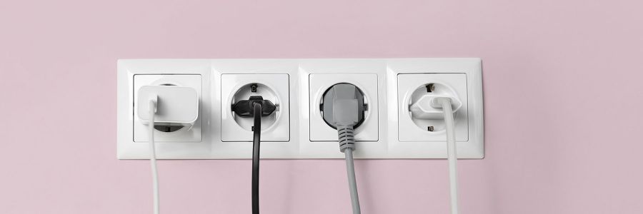 Steckdosenleiste vor einer rosa Wand